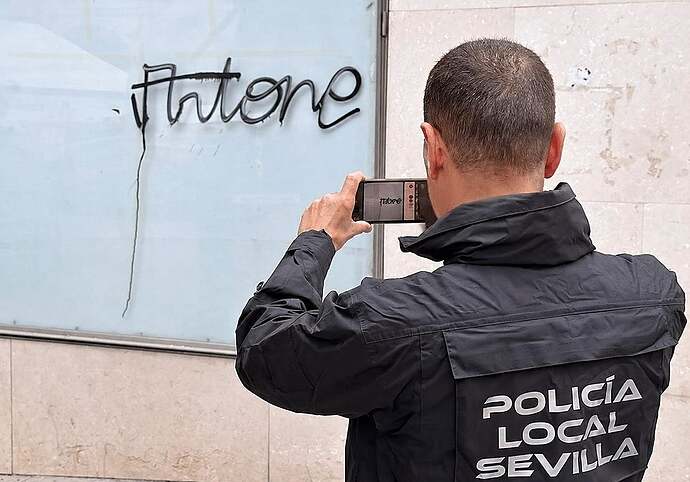 Un agente de la Policía Local documenta una de las pintadas vandálicas de 'Artone'.
